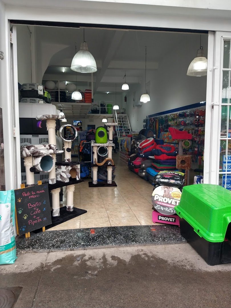 Entrada del local de Dame La Pata con rascadores, camas y la pizarra de promos de baño y corte